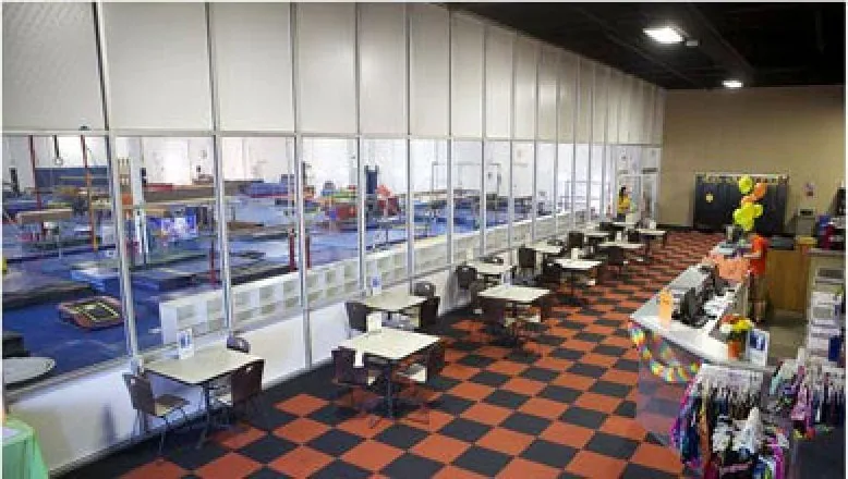 EGA’s lobby: tables and chairs in front of the glass wall that looks onto the main gym